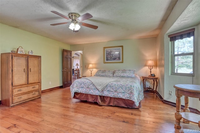 bedroom featuring a textured ceiling, light hardwood / wood-style flooring, and ceiling fan