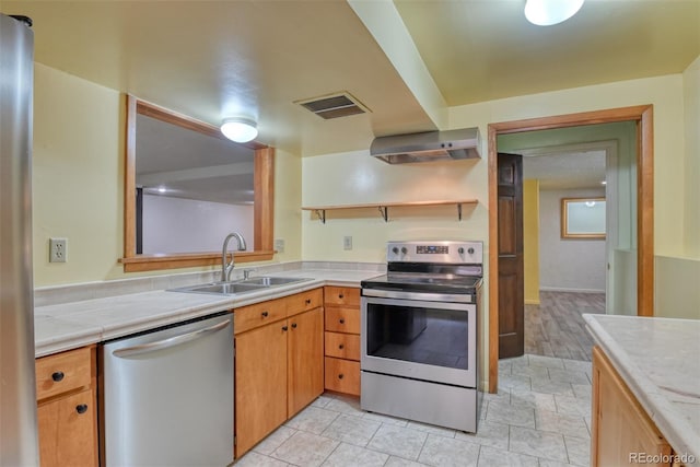 kitchen with sink, wall chimney range hood, and appliances with stainless steel finishes