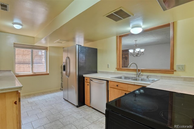 kitchen with stainless steel appliances, sink, light tile patterned floors, and a notable chandelier