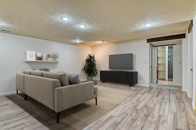 living room featuring a textured ceiling and light wood-type flooring