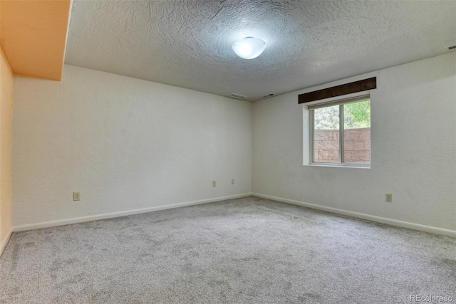 spare room with a textured ceiling and carpet floors