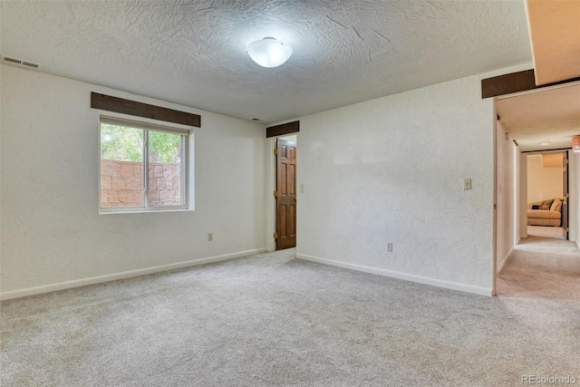 carpeted spare room with a textured ceiling