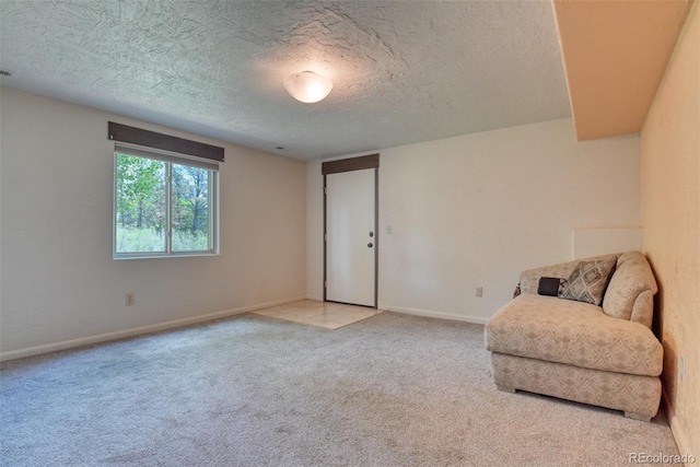 living area with light carpet and a textured ceiling