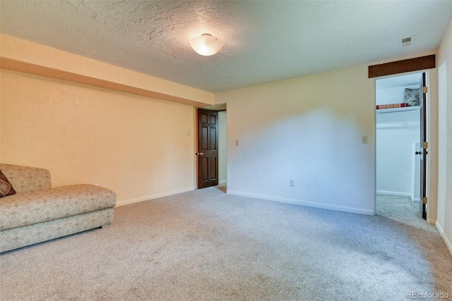 sitting room featuring carpet floors and a textured ceiling