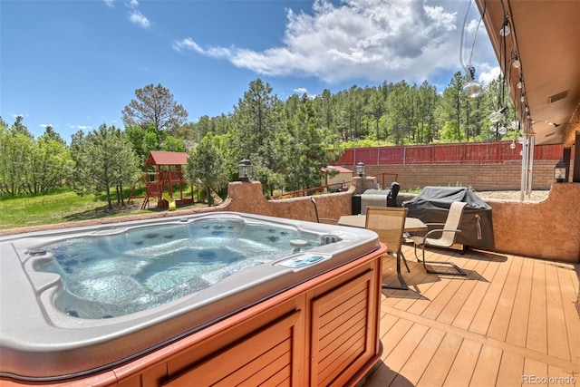 view of swimming pool featuring a hot tub and a deck