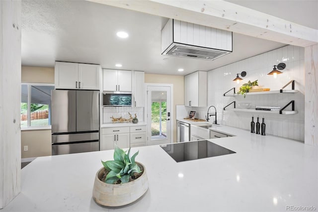 13249 W Jewell Pl, Lakewood, CO 80228 - kitchen featuring stainless steel appliances, light countertops, open shelves, decorative backsplash, and white cabinets
