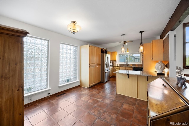 3900 Bogey Ct, Longmont, CO 80503 - kitchen with stainless steel fridge, a peninsula, decorative light fixtures, light brown cabinets, and a sink