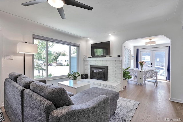 6179 S Bemis St, Littleton, CO 80120 - living room featuring a ceiling fan, wood finished floors, a brick fireplace, french doors, and baseboards