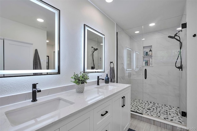 6179 S Bemis St, Littleton, CO 80120 - bathroom featuring a stall shower, double vanity, a textured wall, and recessed lighting