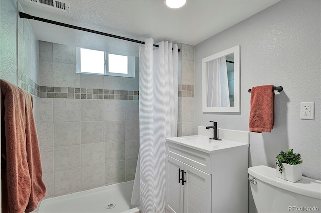 6179 S Bemis St, Littleton, CO 80120 - full bath with toilet, tiled shower, vanity, and a textured wall