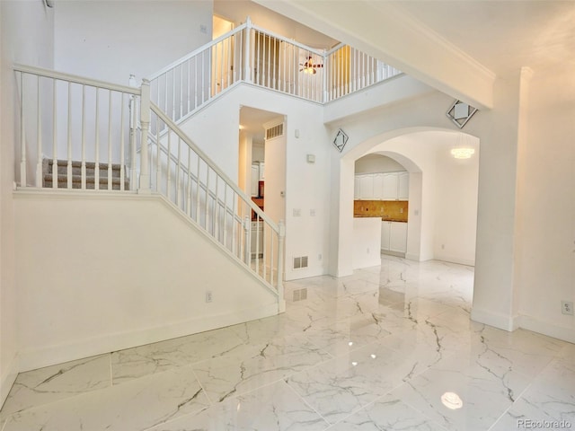 15501 E 112th Ave Unit 35B, Commerce City, CO 80022 - entrance foyer featuring marble tiled flooring, stairway, arched walkways, and a high ceiling