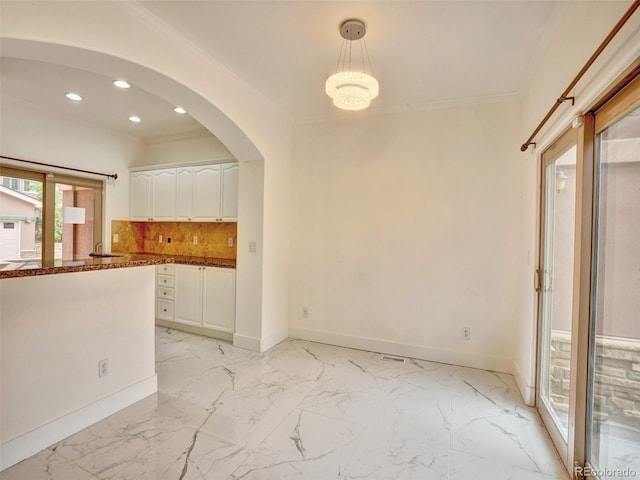 15501 E 112th Ave Unit 35B, Commerce City, CO 80022 - kitchen featuring white cabinetry, ornamental molding, recessed lighting, tasteful backsplash, and arched walkways