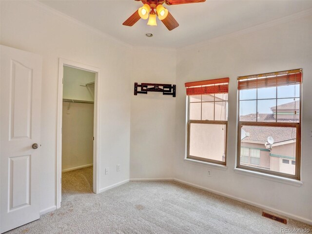 15501 E 112th Ave Unit 35B, Commerce City, CO 80022 - unfurnished bedroom featuring a walk in closet, ornamental molding, carpet floors, and a ceiling fan