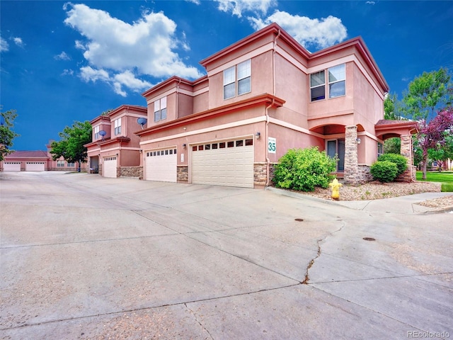 15501 E 112th Ave Unit 35B, Commerce City, CO 80022 - view of front of home with stone siding, stucco siding, a garage, and concrete driveway