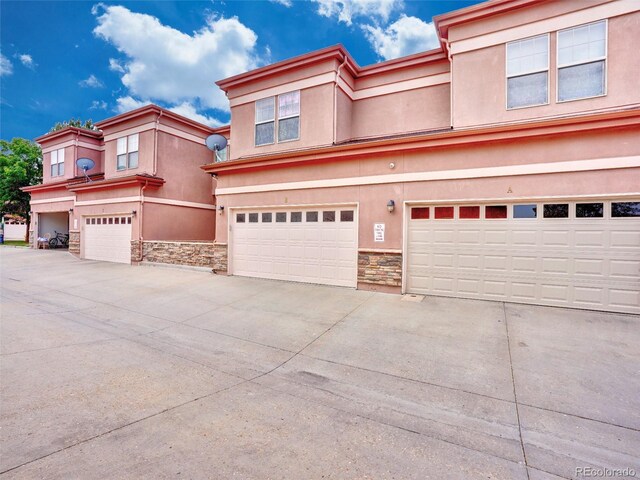 15501 E 112th Ave Unit 35B, Commerce City, CO 80022 - view of front of property with stone siding, stucco siding, concrete driveway, and an attached garage