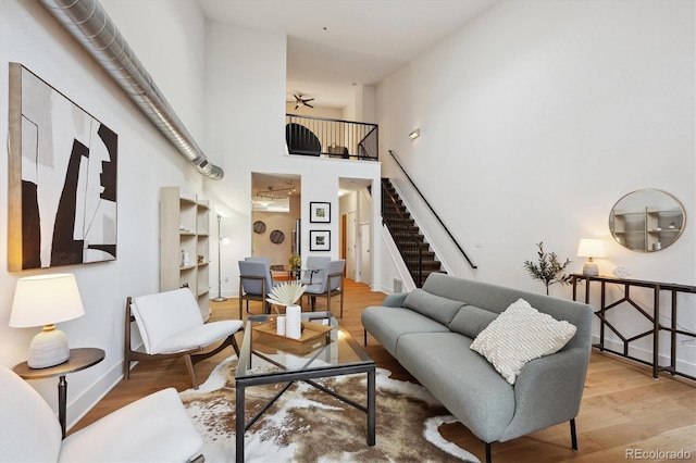 living room featuring light wood-type flooring and a high ceiling