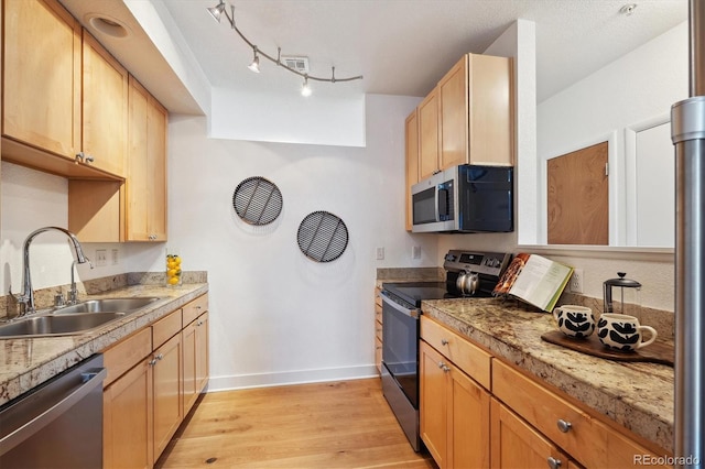 kitchen featuring light brown cabinetry, sink, light hardwood / wood-style floors, and appliances with stainless steel finishes