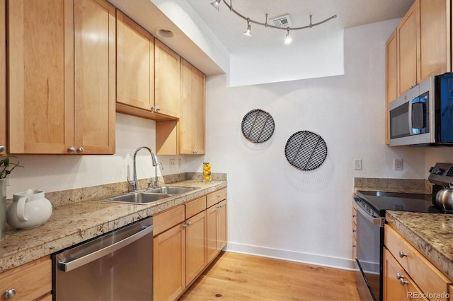 kitchen featuring light brown cabinetry, sink, light hardwood / wood-style flooring, track lighting, and stainless steel appliances