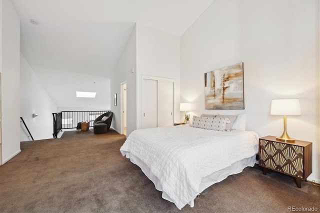 carpeted bedroom with high vaulted ceiling