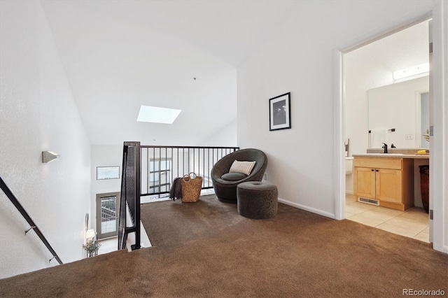 living area featuring sink, light colored carpet, and a skylight