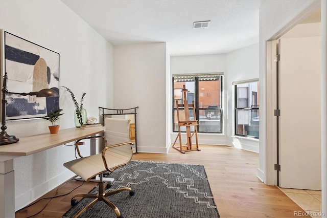 home office with light hardwood / wood-style floors