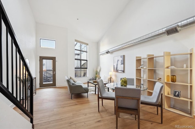 3195 Blake St Unit 201, Denver, CO 80205 - dining room with high vaulted ceiling, light wood-style floors, and stairs
