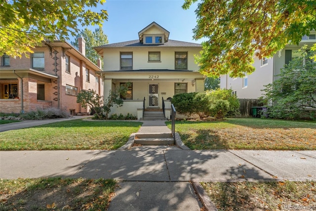 view of front facade with a front yard and covered porch