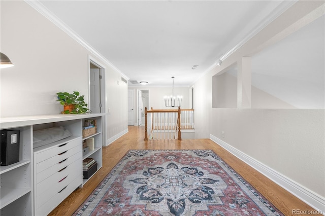 8535 E Otero Cir, Centennial, CO 80112 - hall featuring a chandelier, wood finished floors, crown molding, and baseboards