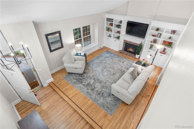 8535 E Otero Cir, Centennial, CO 80112 - living room with wood finished floors, baseboards, a brick fireplace, built in features, and lofted ceiling