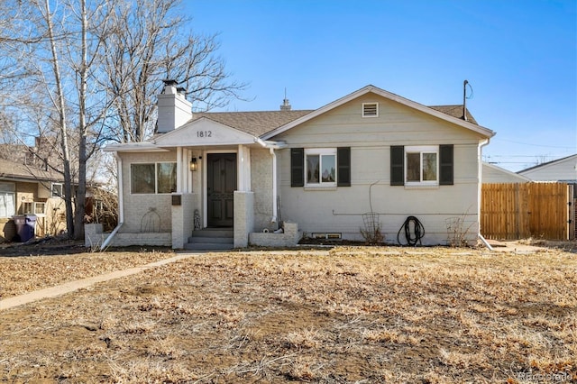 bungalow-style house with roof with shingles, crawl space, a chimney, and fence