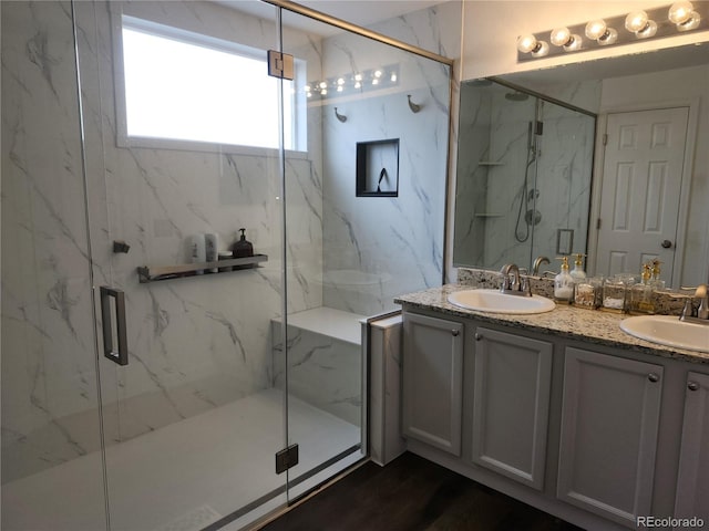 21924 E Lake Ave, Aurora, CO 80015 - full bathroom featuring double vanity, a marble finish shower, and wood finished floors