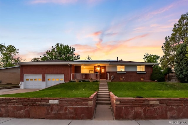 5947 W 65th Ave, Arvada, CO 80003 - view of front facade with brick siding, driveway, roof mounted solar panels, and a garage