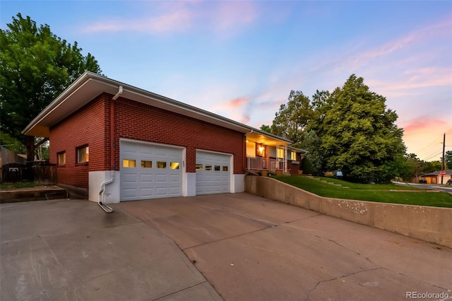 5947 W 65th Ave, Arvada, CO 80003 - property exterior at dusk with concrete driveway, brick siding, and an attached garage