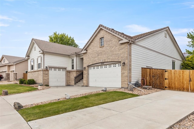 4545 Oxbow Dr, Brighton, CO 80601 - view of side of property featuring driveway, brick siding, and a tile roof
