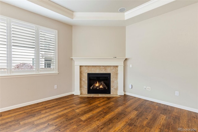 4545 Oxbow Dr, Brighton, CO 80601 - unfurnished living room with a tray ceiling, ornamental molding, wood finished floors, a tiled fireplace, and baseboards
