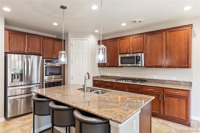 4545 Oxbow Dr, Brighton, CO 80601 - kitchen with stainless steel appliances, a sink, light stone countertops, a kitchen island with sink, and recessed lighting