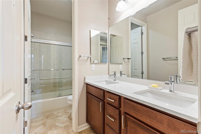 4545 Oxbow Dr, Brighton, CO 80601 - bathroom featuring double vanity, toilet, and shower / bath combination with glass door