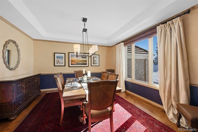 dining space featuring an inviting chandelier, dark hardwood / wood-style flooring, and a tray ceiling