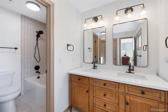 full bathroom with tiled shower / bath combo, vanity, tile patterned floors, and toilet