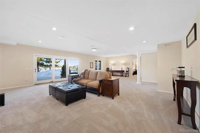 living room featuring light colored carpet and decorative columns