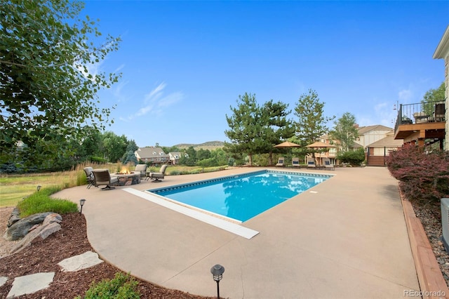 view of swimming pool with a patio area and an outdoor fire pit