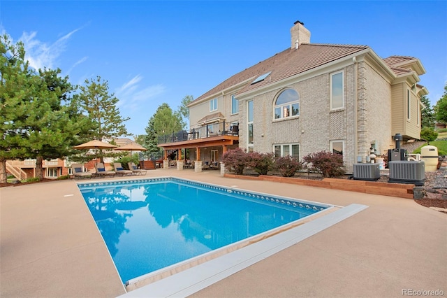 view of pool featuring central AC unit and a patio area