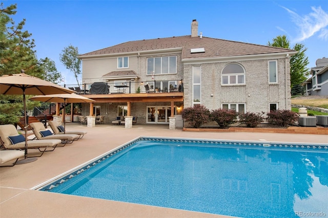 view of swimming pool with central AC unit and a patio area