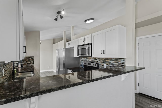 8979 Lariat Loop, Elizabeth, CO 80107 - kitchen with appliances with stainless steel finishes, decorative backsplash, dark stone counters, and white cabinets