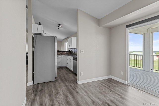 8979 Lariat Loop, Elizabeth, CO 80107 - kitchen featuring stainless steel appliances, wood finished floors, white cabinets, and dark countertops