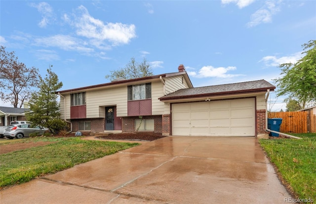 split foyer home featuring brick siding, an attached garage, concrete driveway, and a chimney