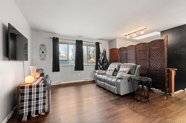 living room featuring wood finished floors, baseboards, and rail lighting
