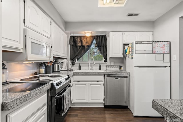 kitchen with white appliances, white cabinets, a sink, and dark wood finished floors