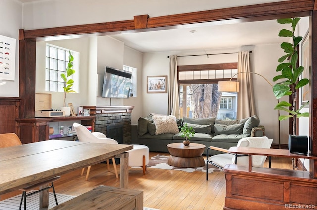 sitting room featuring a brick fireplace and light hardwood / wood-style flooring