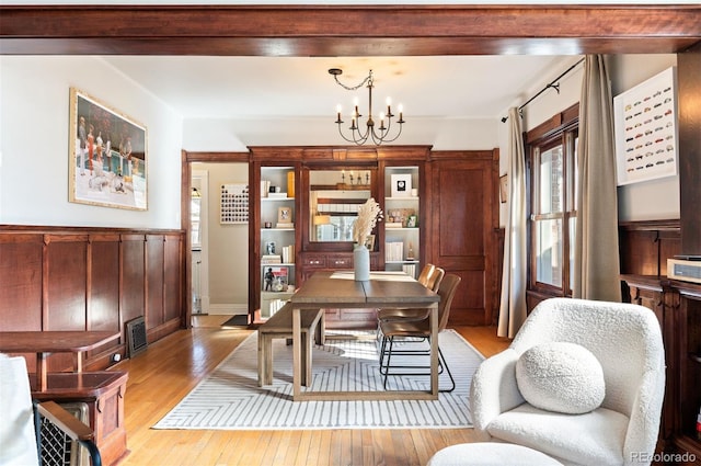 office with light hardwood / wood-style flooring and a notable chandelier